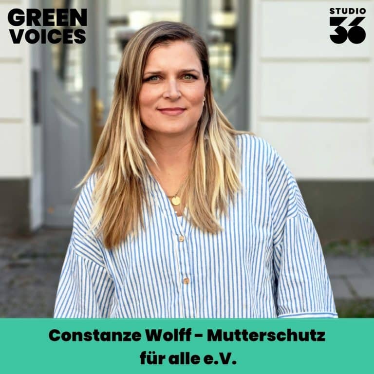 Constanze Wolff steht vor einer hellen Wand, trägt ein gestreiftes Hemd und lächelt, mit dem Text "Mutterschutz für all...