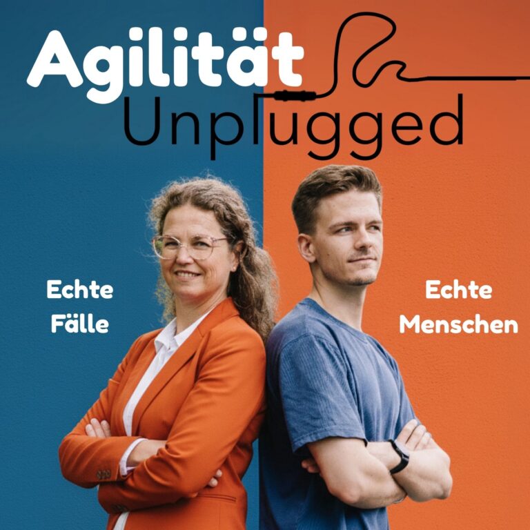 Zwei Personen stehen vor einem zweifarbigen Hintergrund, eine Frau in einem roten Blazer und ein Mann in einem blauen T-Sh...